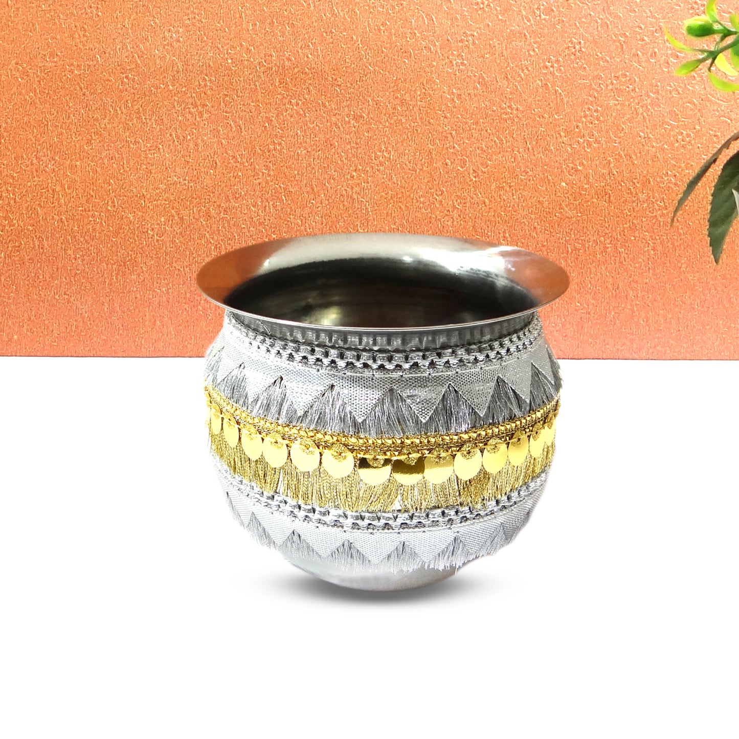 Decorative metal pot with gold accents on a white background