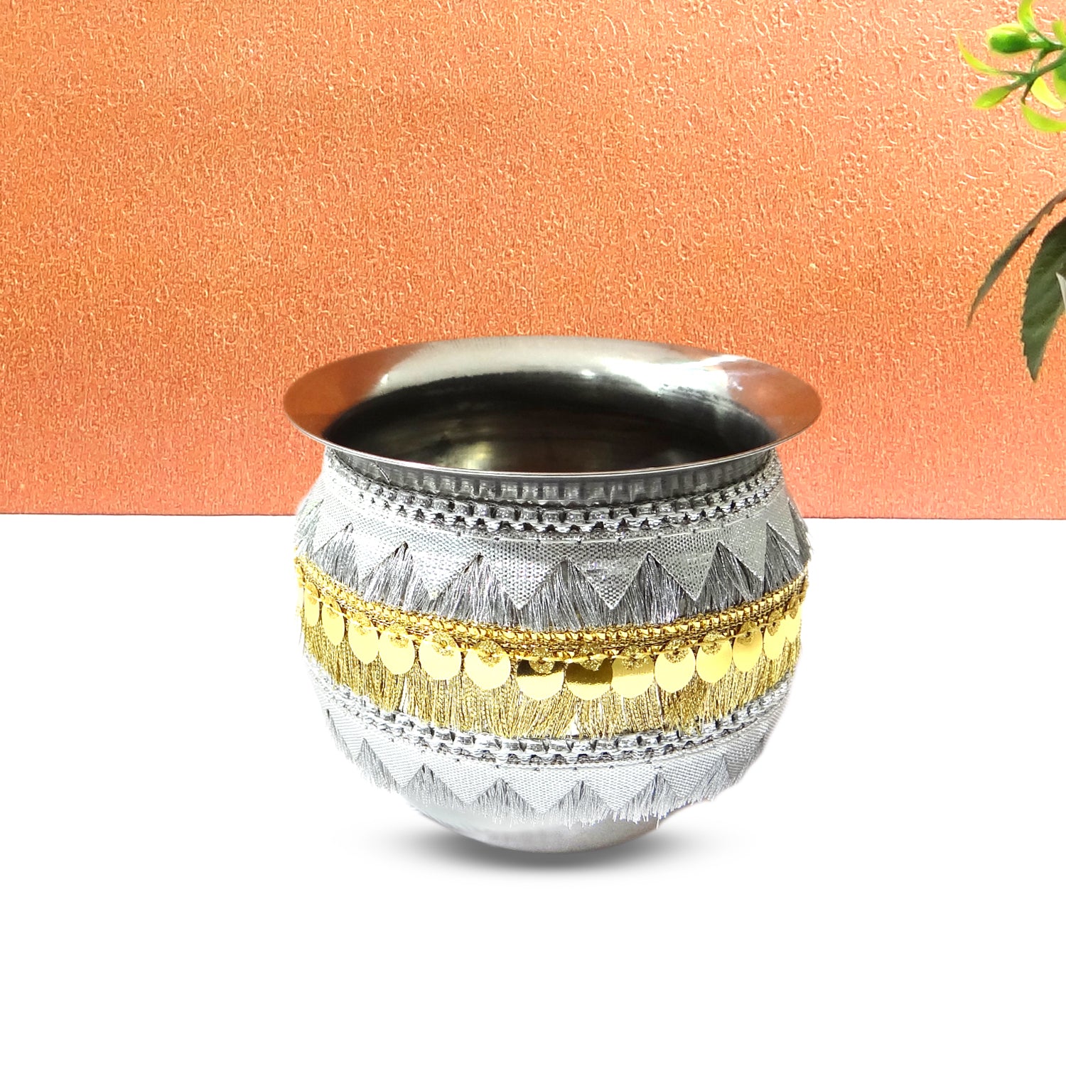 Decorative metal pot with gold accents on a white background