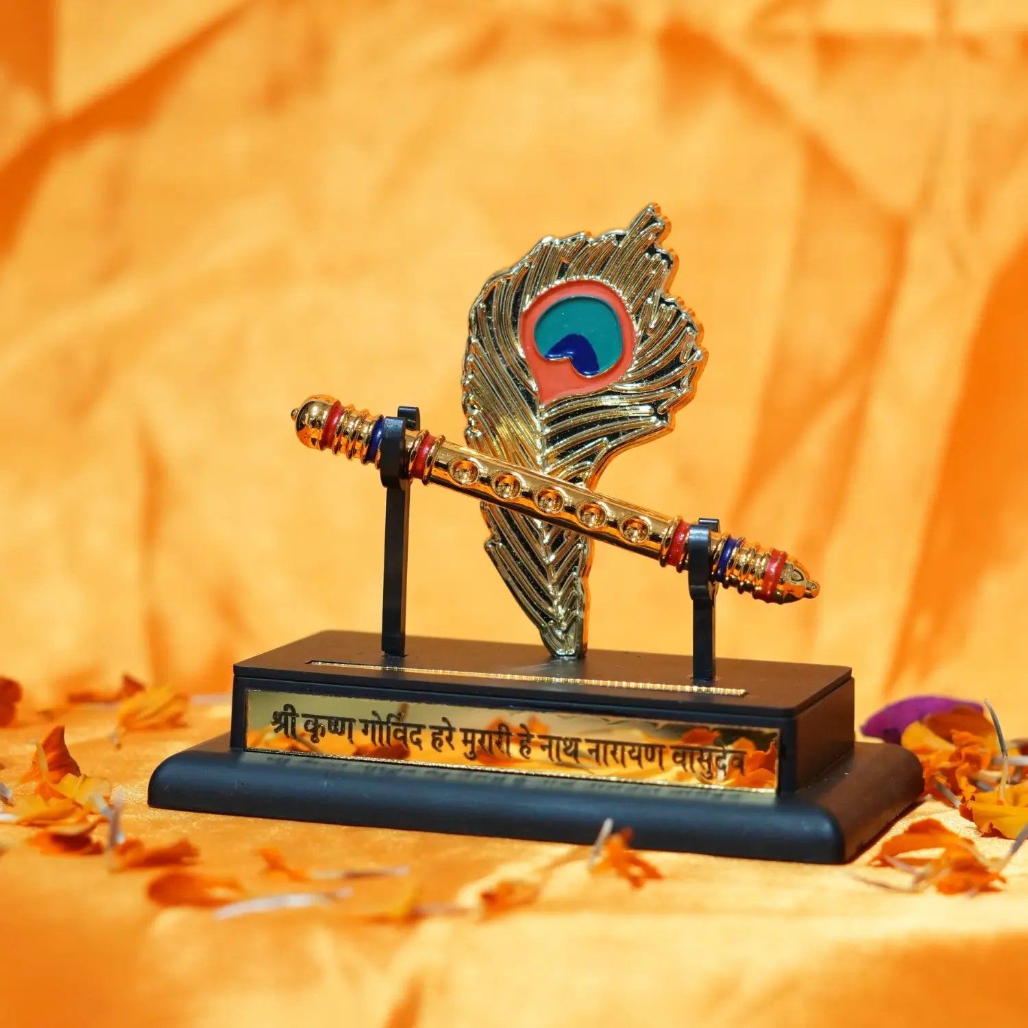 Decorative item resembling a flute with peacock feather design on an orange background