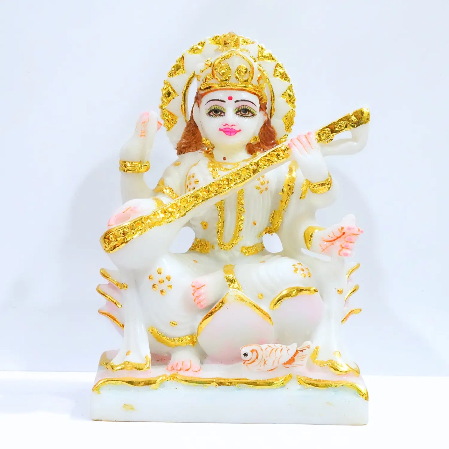 Decorative statue of a deity with gold and white colors on a light blue background