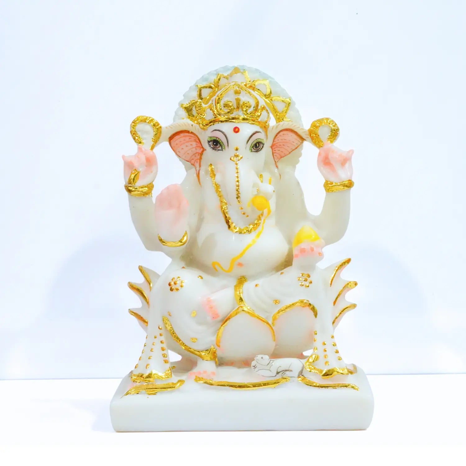 Decorative statue of a deity with gold and pink accents on a white background