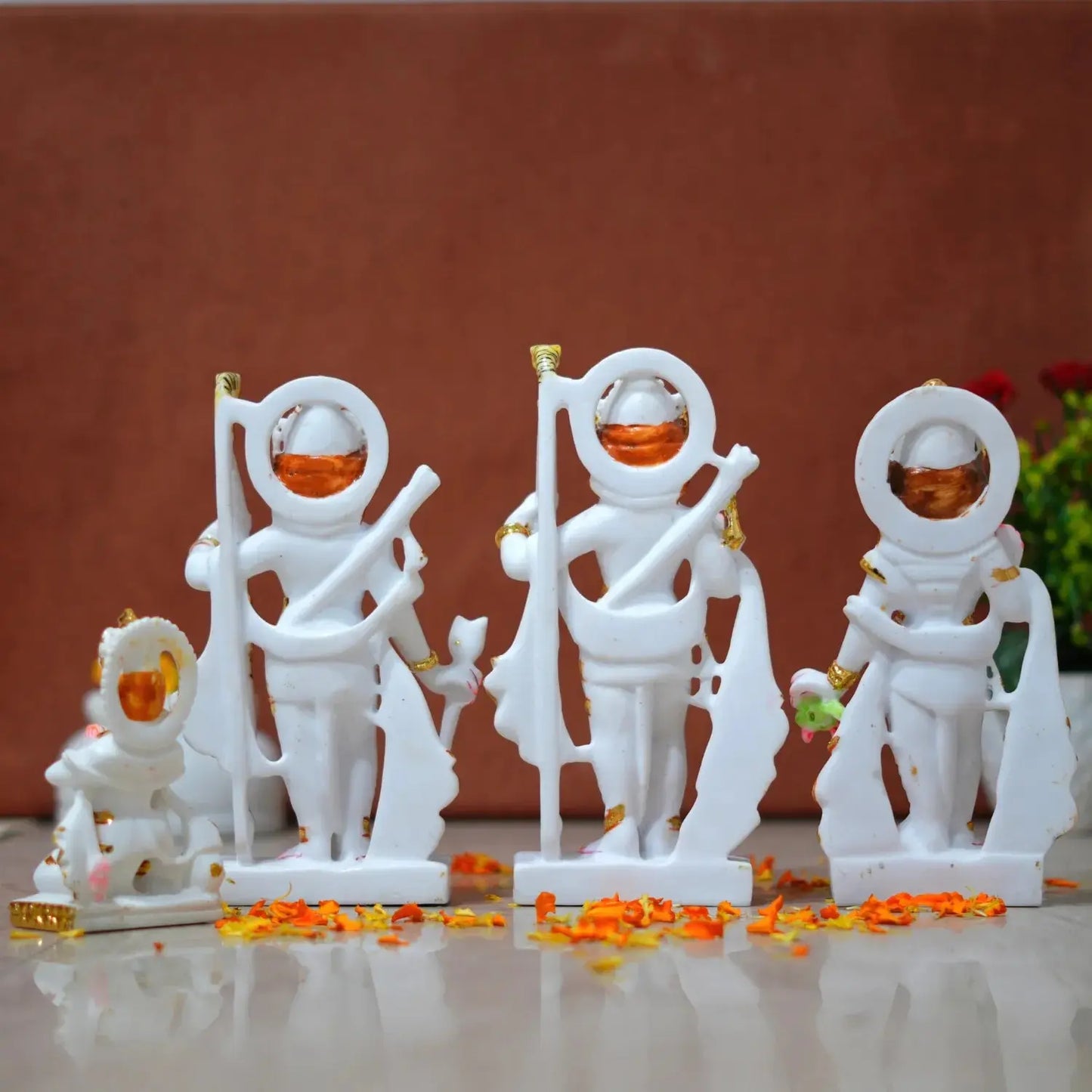 White figurines with orange accents on a reflective surface against a brown background
