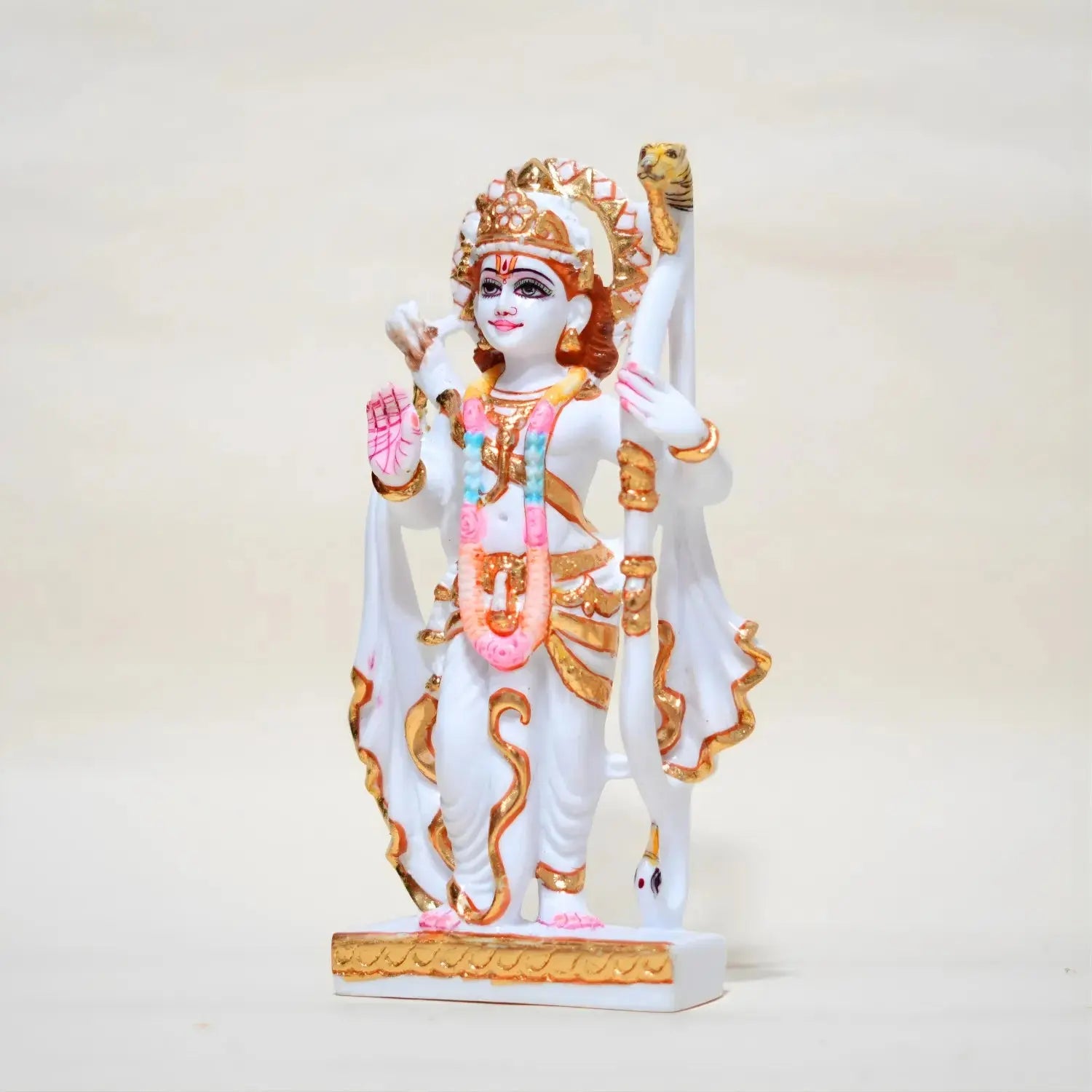 Statue of a deity with white and gold colors on a light beige background