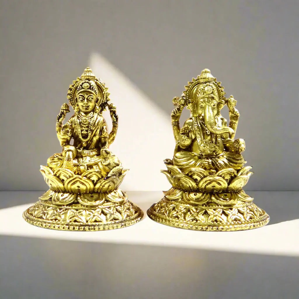 Two gold-colored statues on a white background