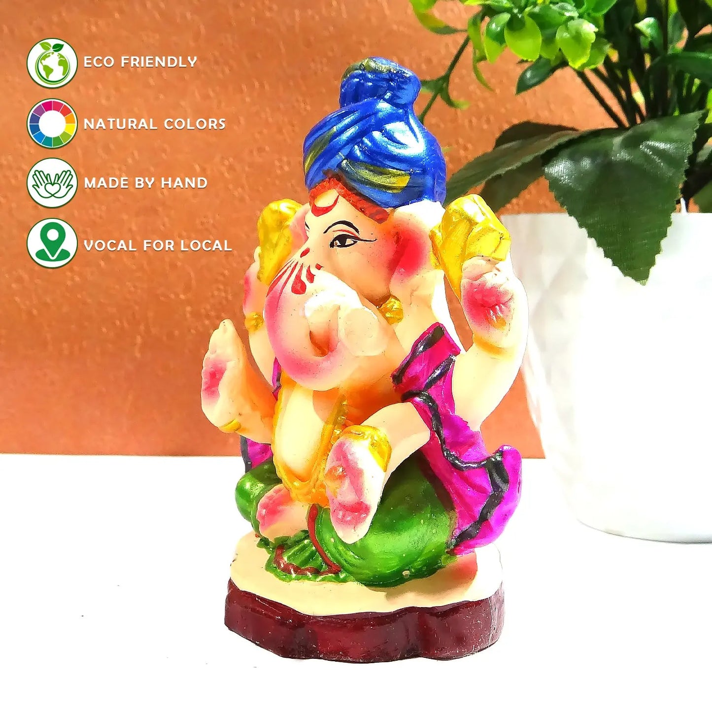 Colorful Ganesha statue with eco-friendly and handcrafted attributes on a white surface.