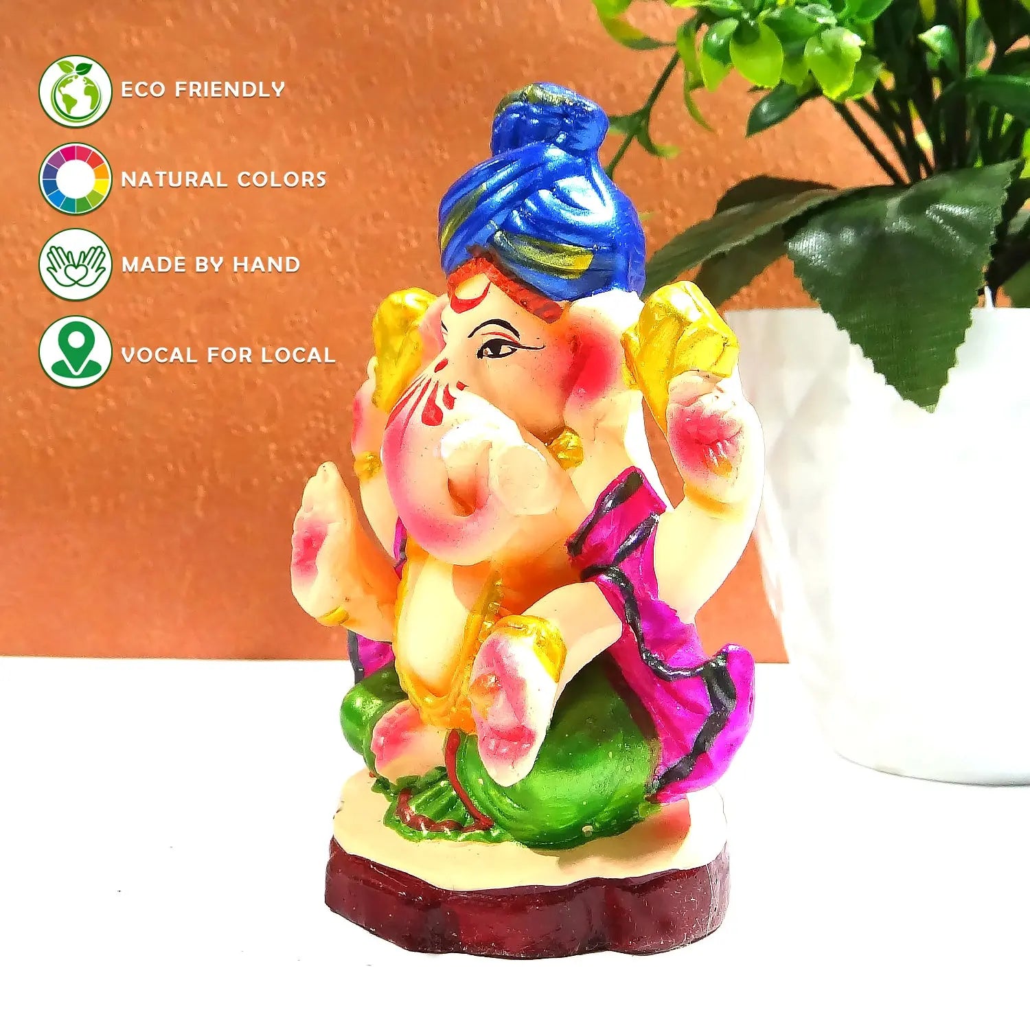 Colorful Ganesha statue with eco-friendly and handcrafted attributes on a white surface.