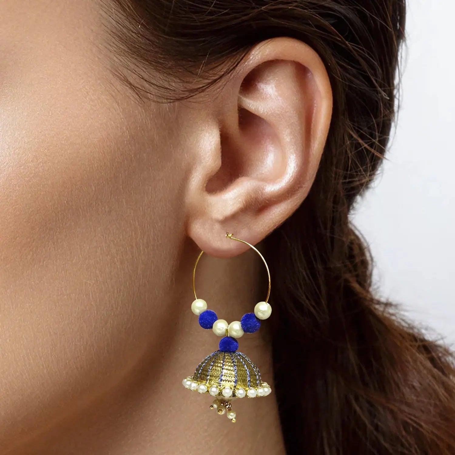 Earring with pearls and blue beads worn by a person