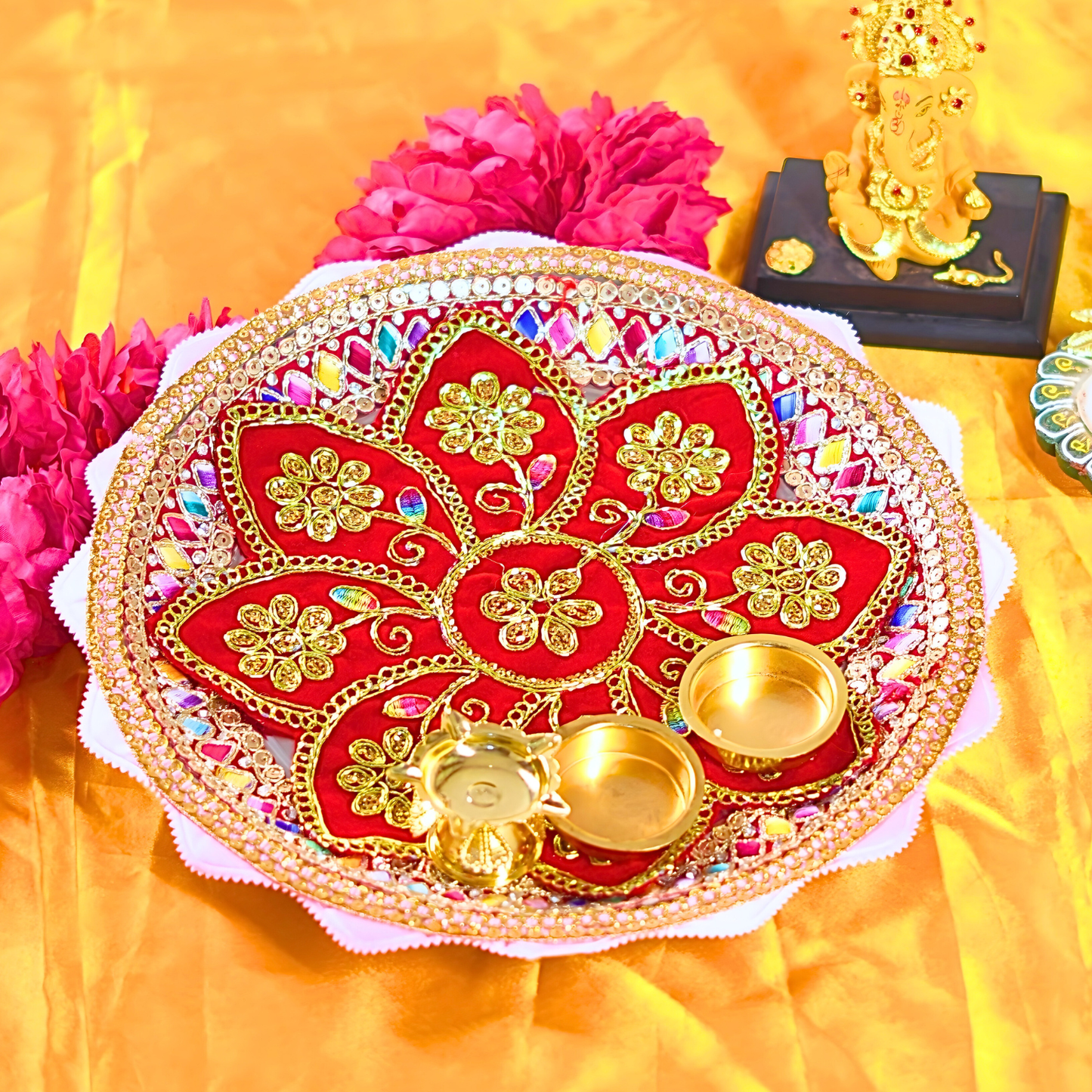 Decorative red and gold plate with flowers and a small statue on a yellow background