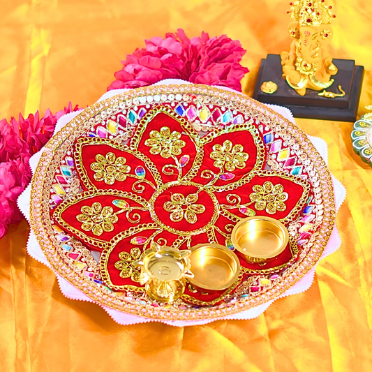 Decorative red and gold plate with flowers and a small statue on a yellow background