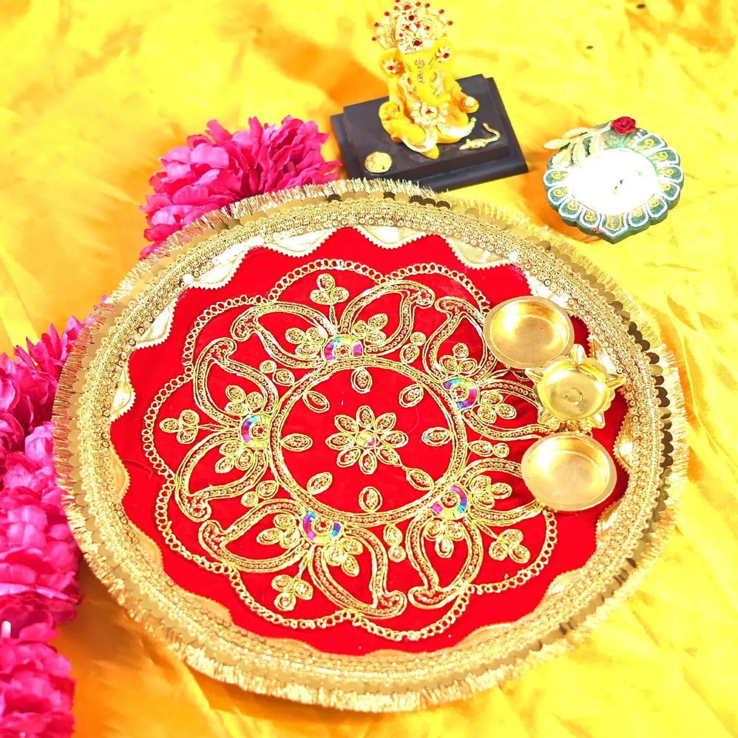 Decorative red and gold plate with flowers and a small statue on a yellow background