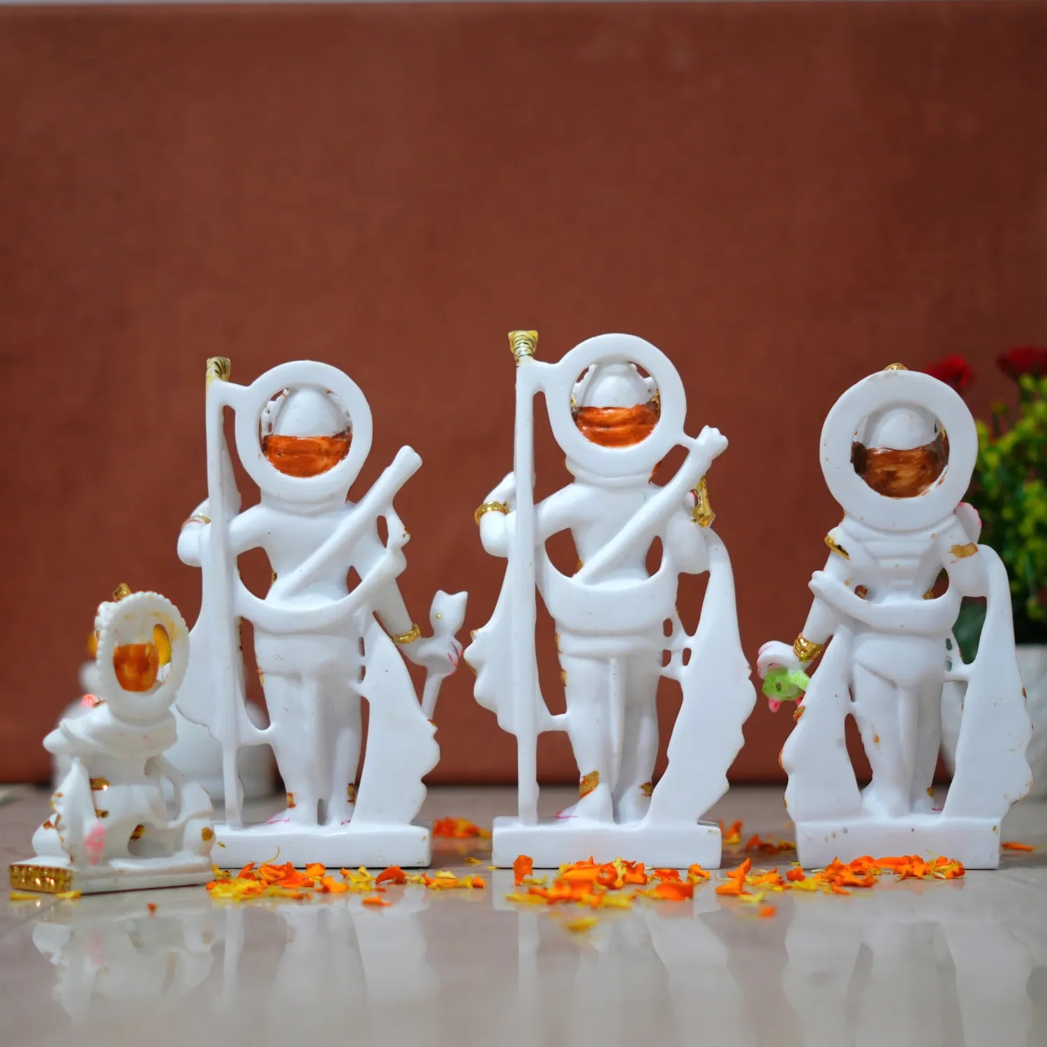 White figurines with orange accents on a reflective surface against a brown background