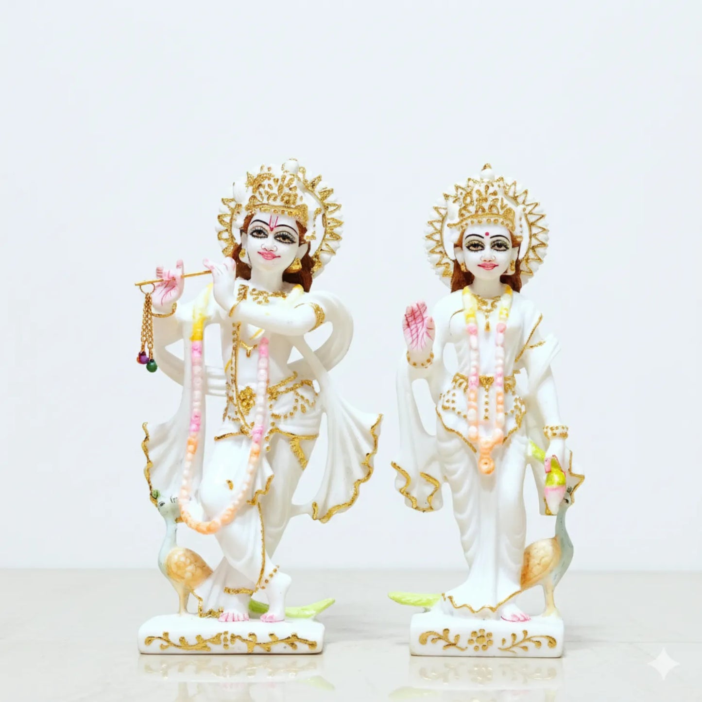 Two ornate statues of deities on a white background