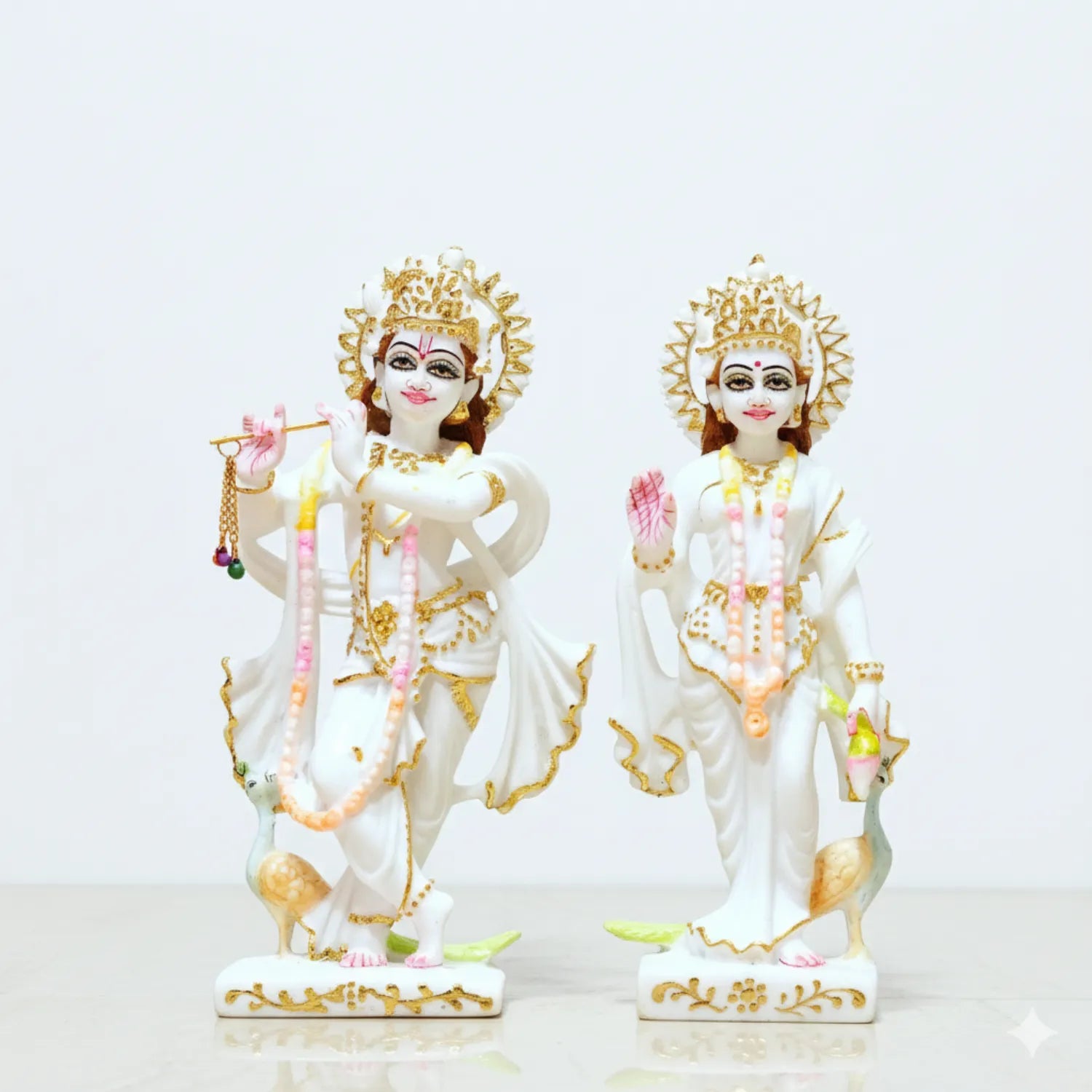 Two ornate statues of deities on a white background