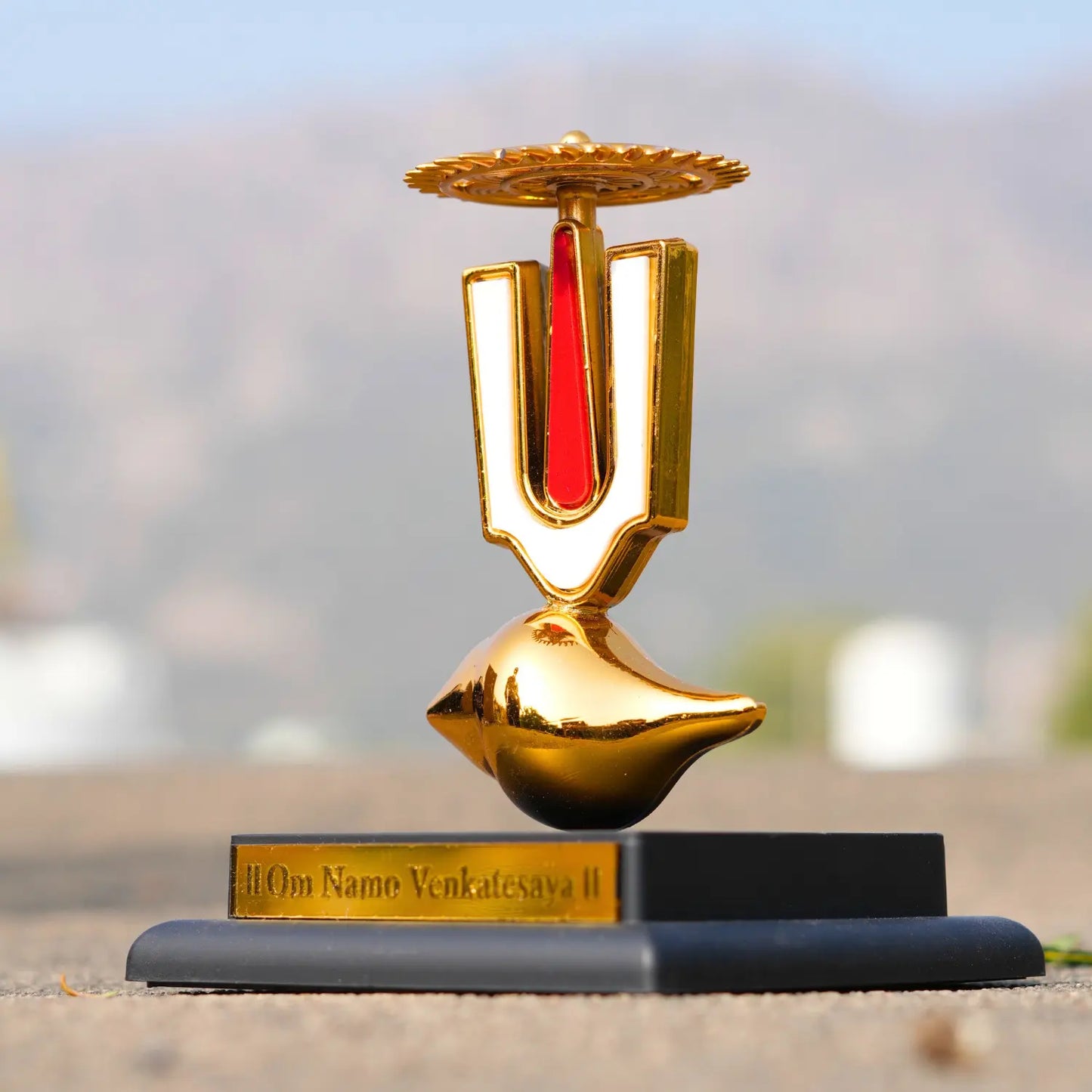 Decorative item with gold and red design on a blurred background