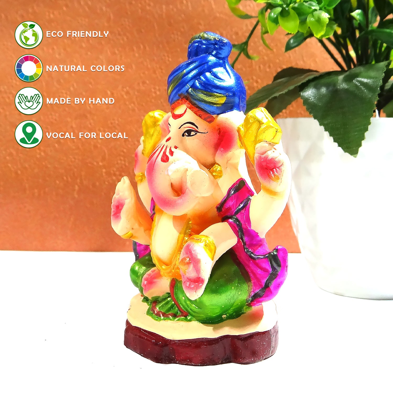 Colorful Ganesha statue with eco-friendly and handcrafted attributes on a white surface.