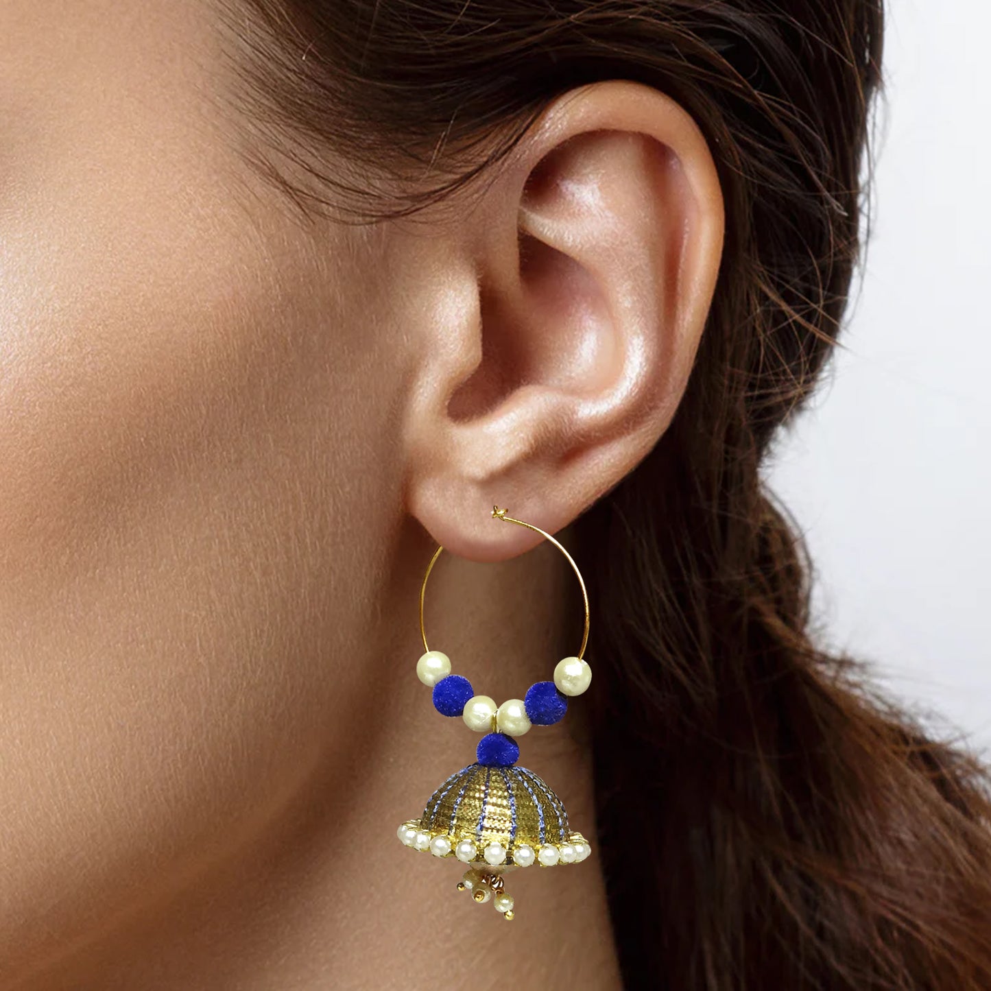 Earring with pearls and blue beads worn by a person