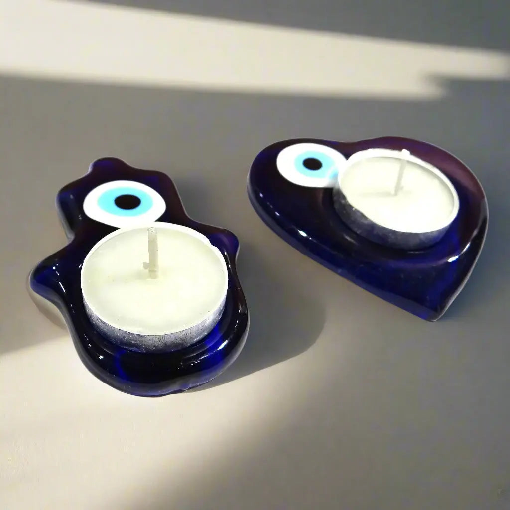 Two blue candle holders with white candles on a white background