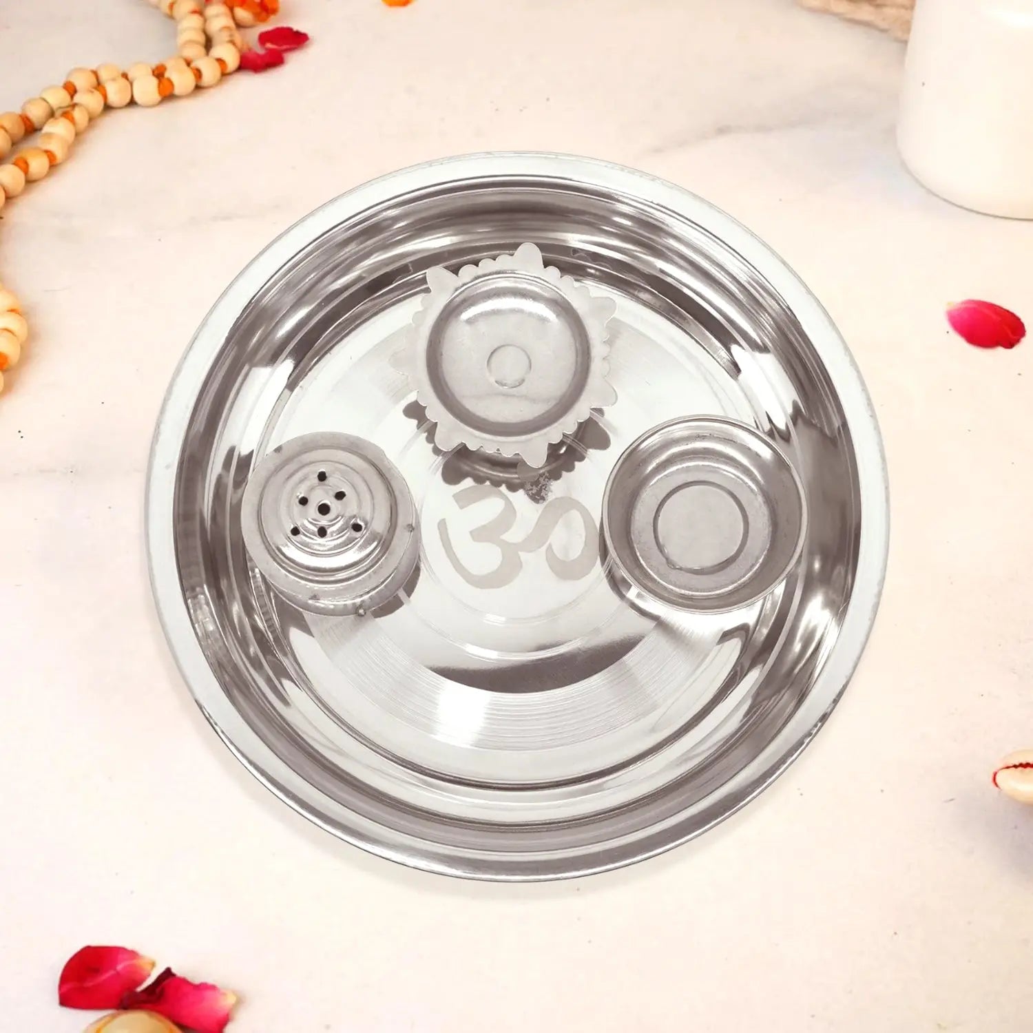 Stainless steel lid with 'om' engraving on a light background