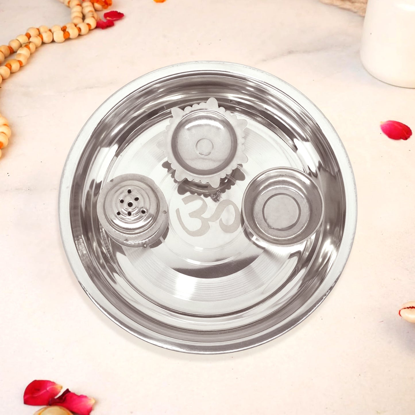 Stainless steel lid with 'om' engraving on a light background