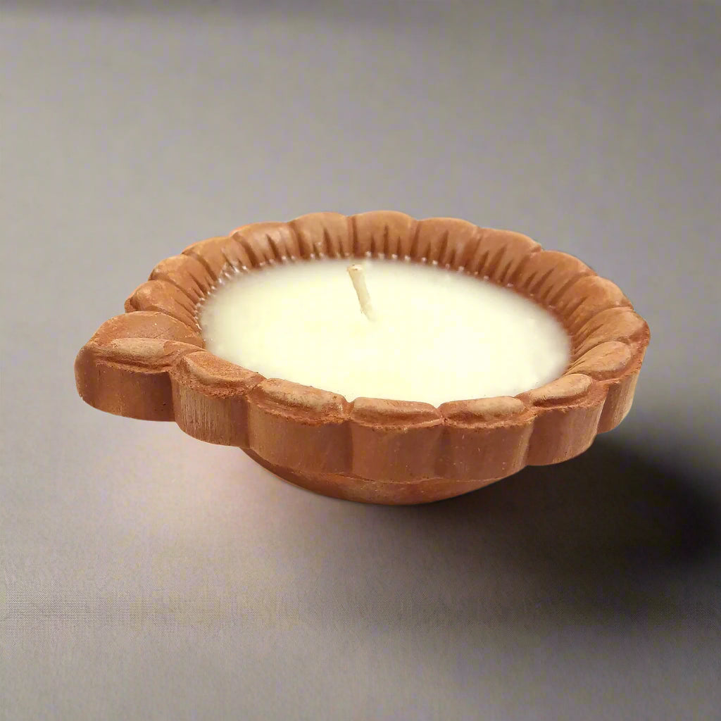 Candle in a decorative wooden holder on a white background