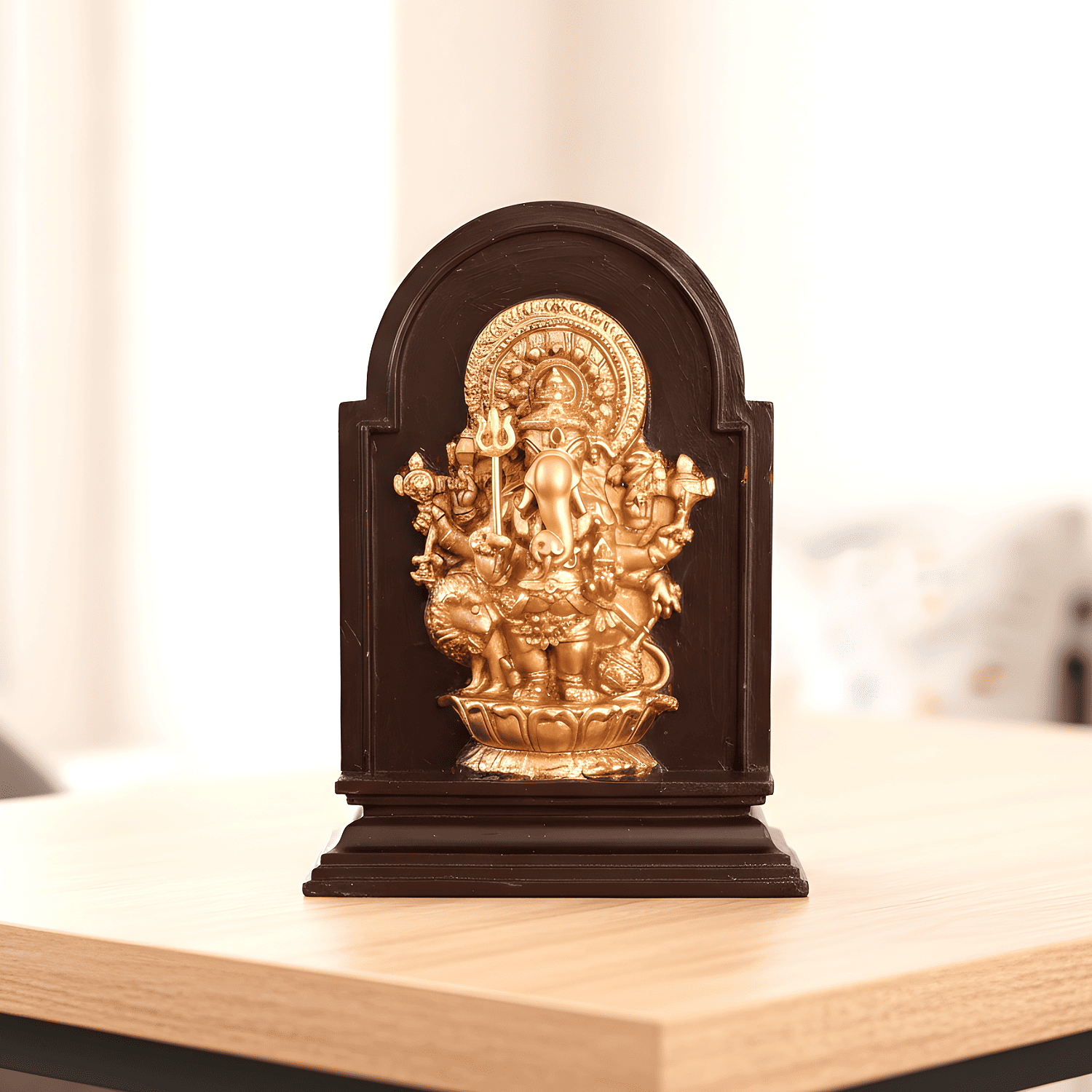 Decorative statue in a dark wooden frame on a light surface with a blurred background