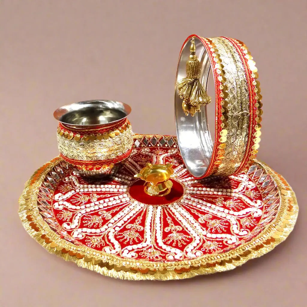 Decorative cup, plate, and bangles on a red and gold tray with an orange background