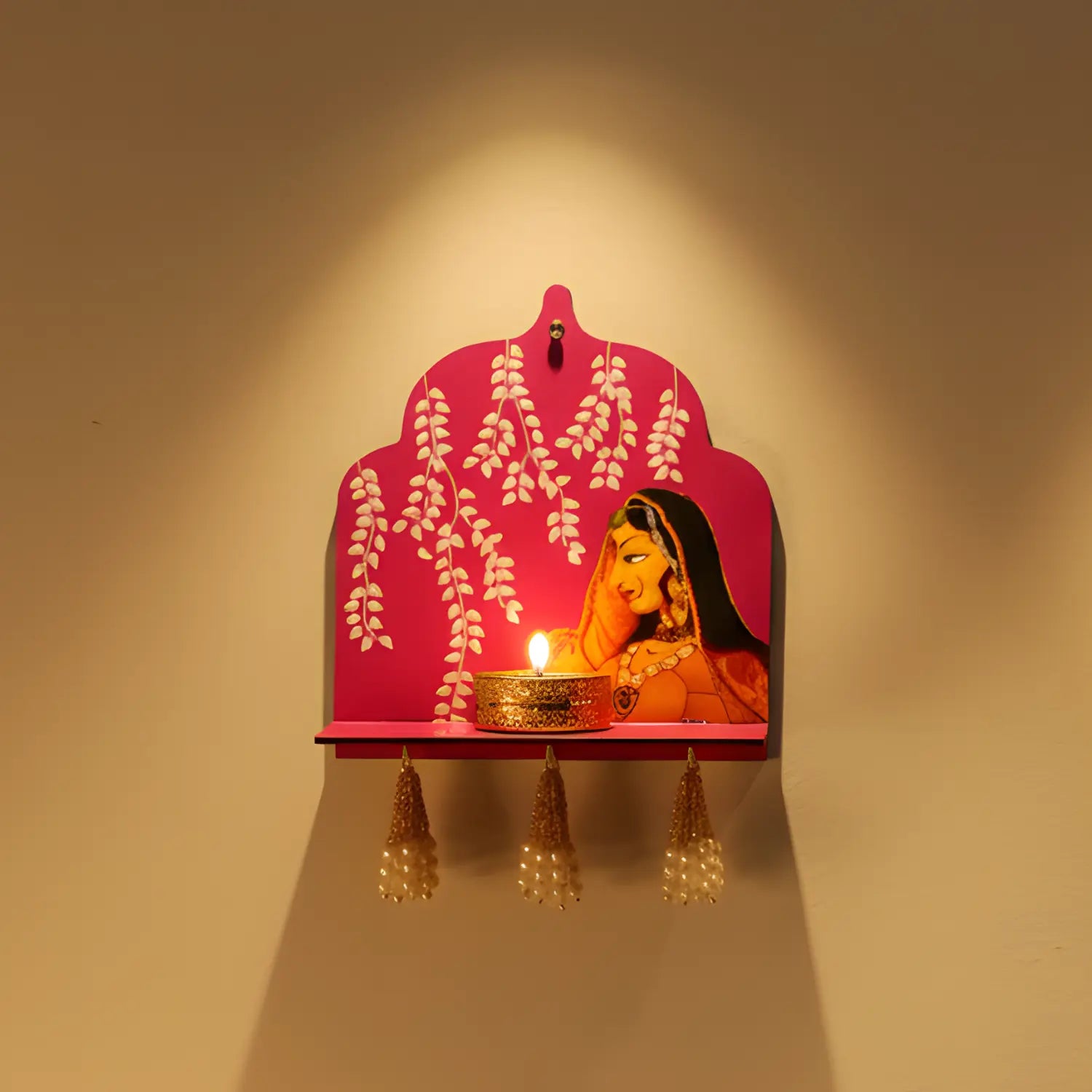 Decorative wall shelf with a pink arch and woman's face design, illuminated by a candle.