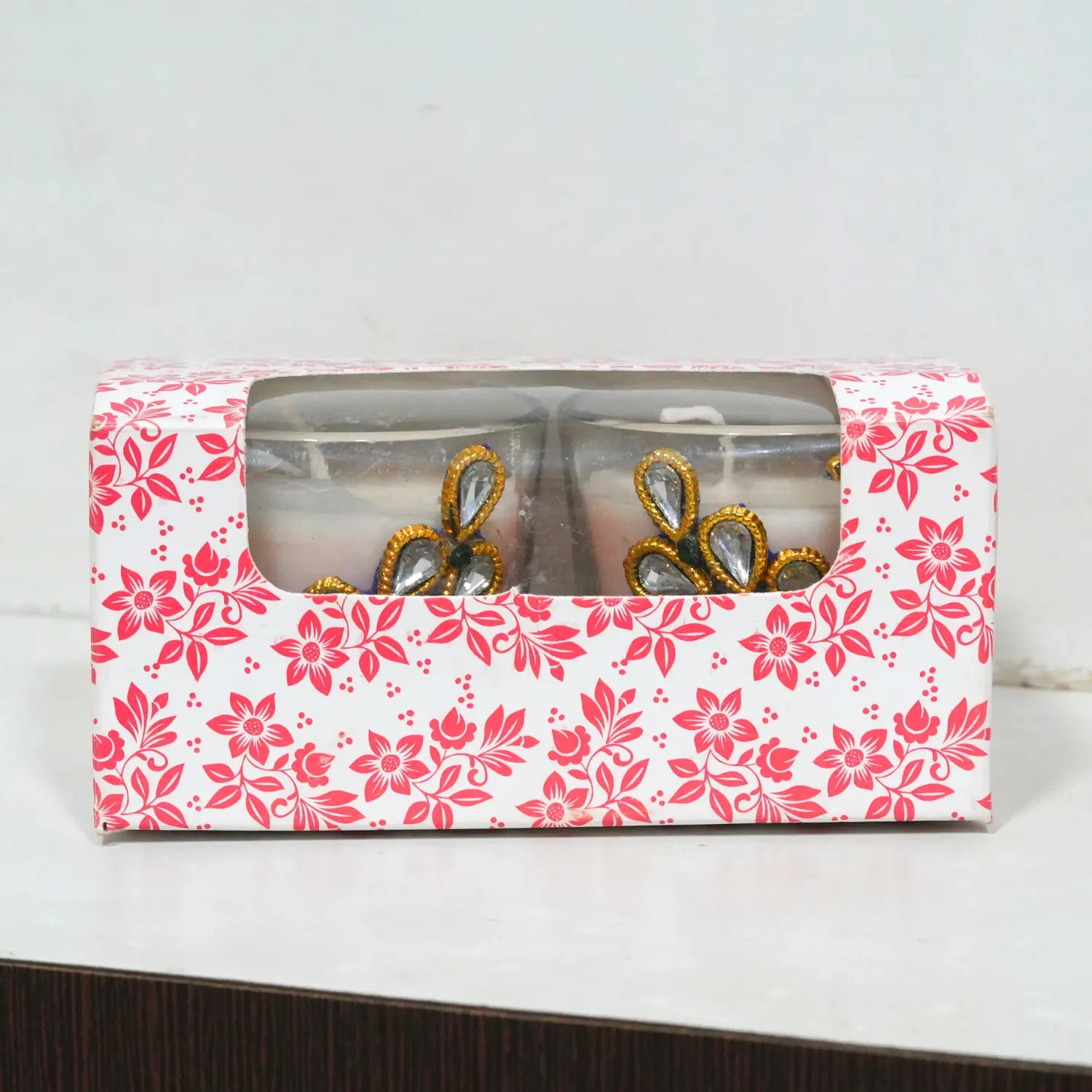 Decorative wall stickers on a beige wall above a wooden shelf with a clock and plants.