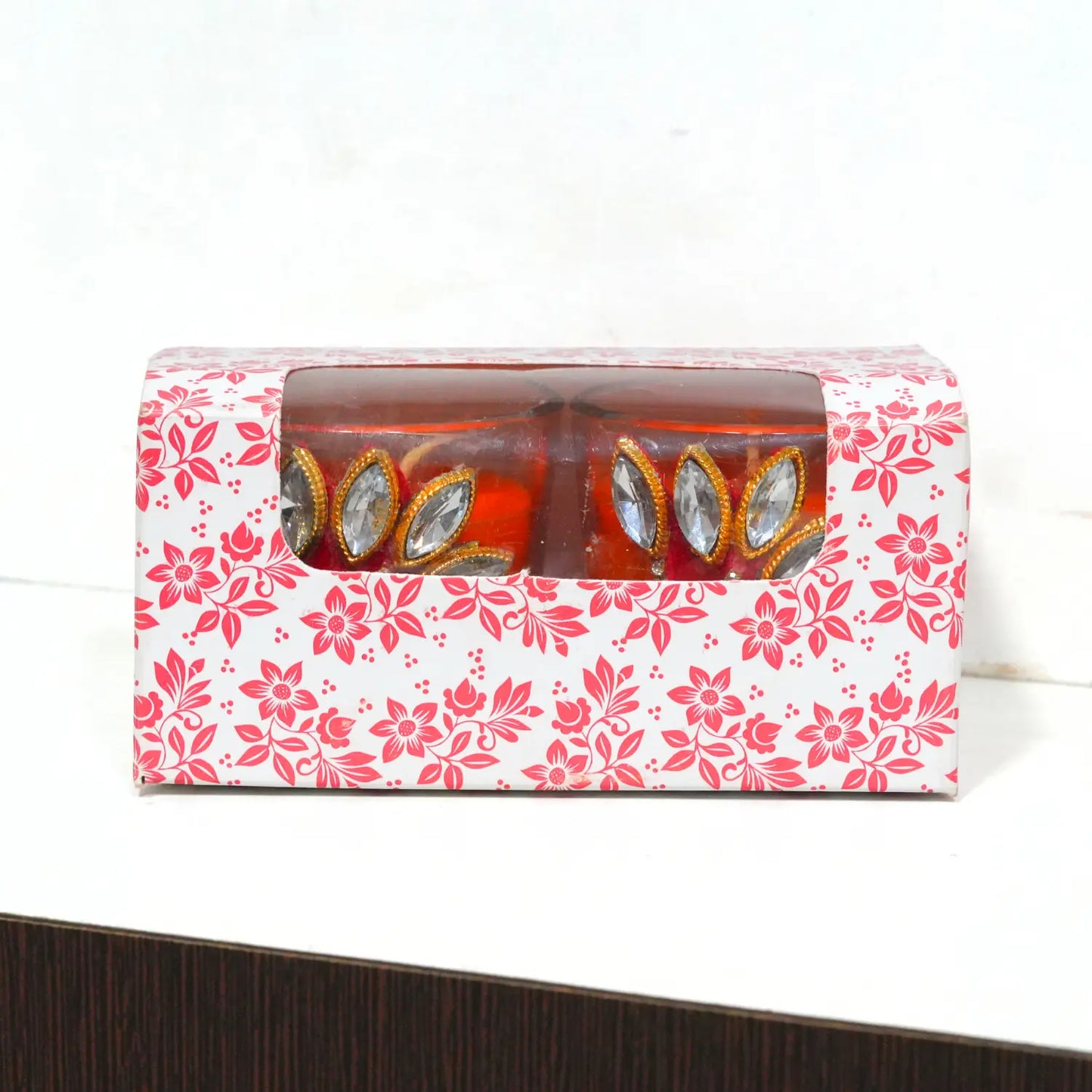 Candle set in a decorative box with floral pattern on a white background