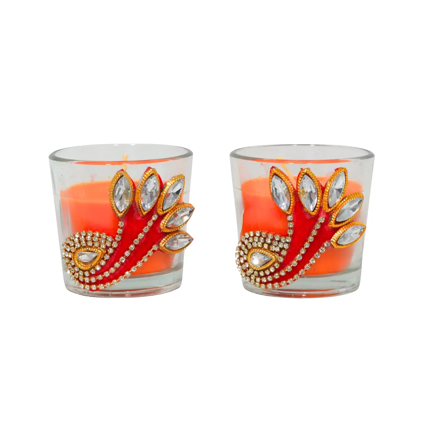Two decorative candles in glass holders with peacock feather design on a white background