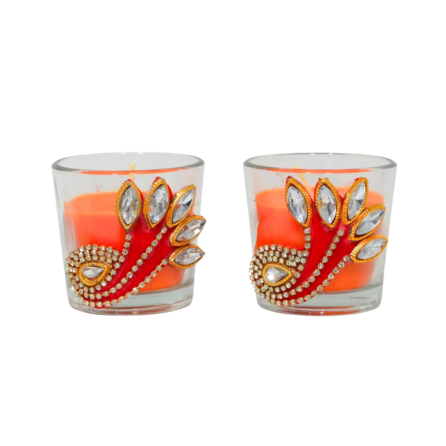 Two decorative candles in glass holders with peacock feather design on a white background
