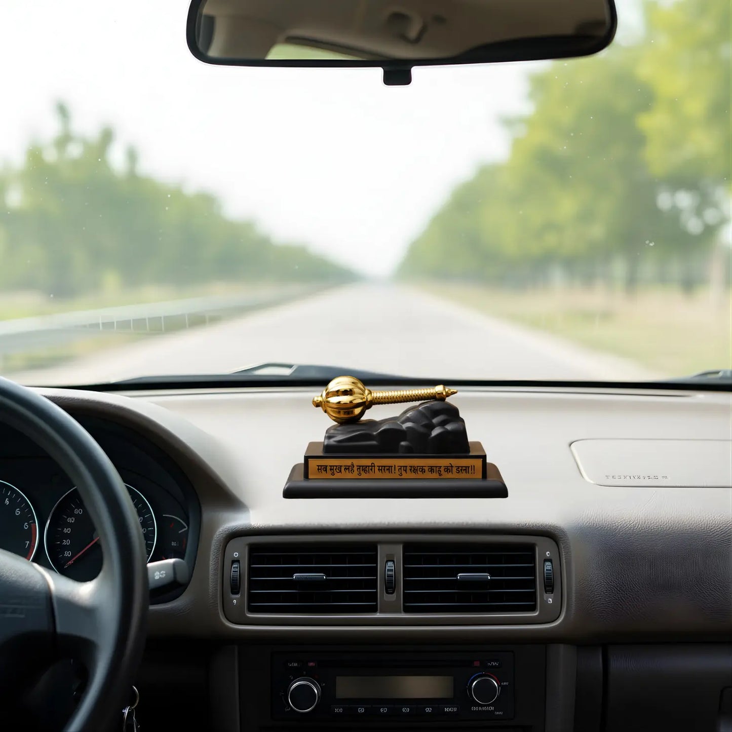 Car dashboard with a decorative item and road ahead