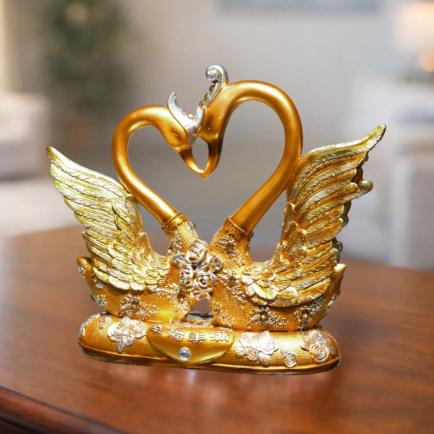 Gold swan sculpture on a wooden surface with a blurred background