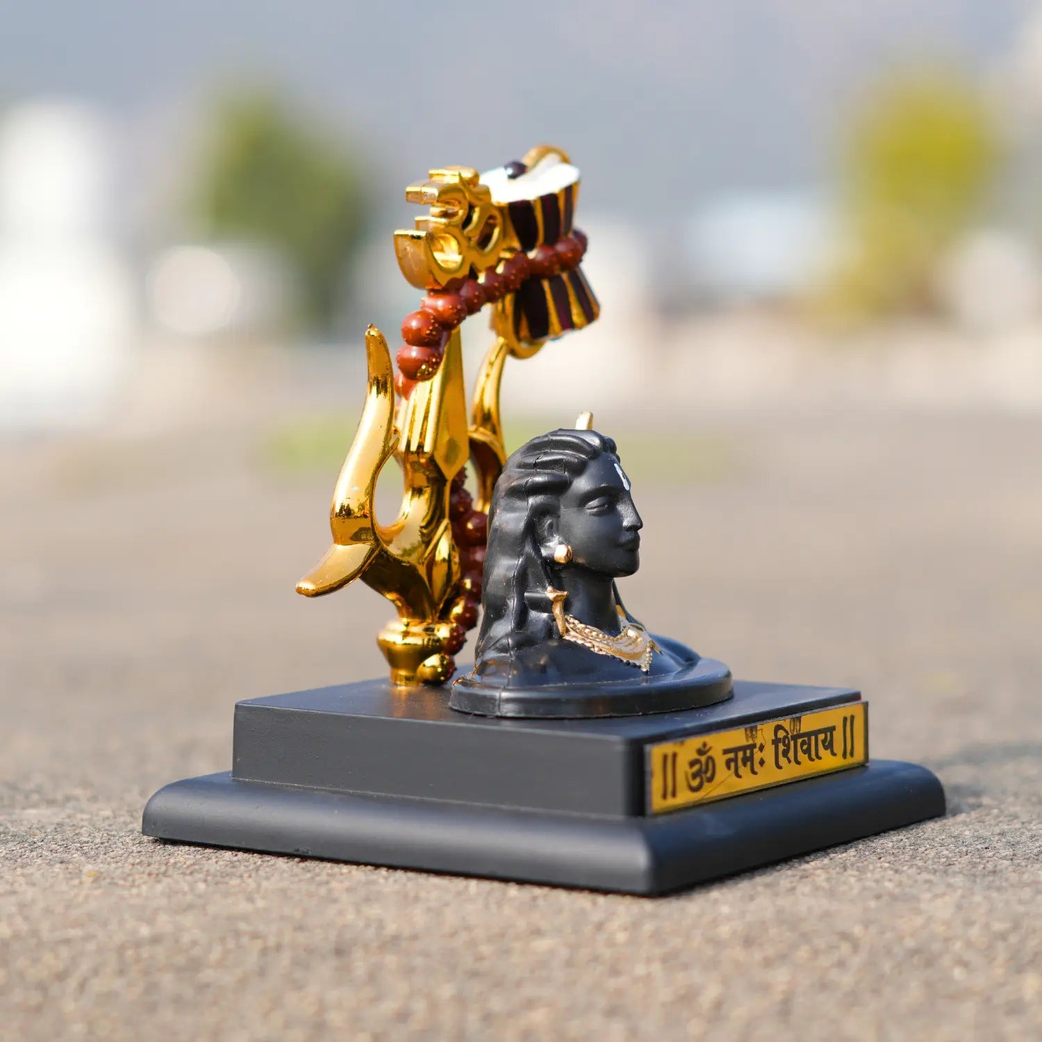 Decorative statue with gold elements on a blurred natural background