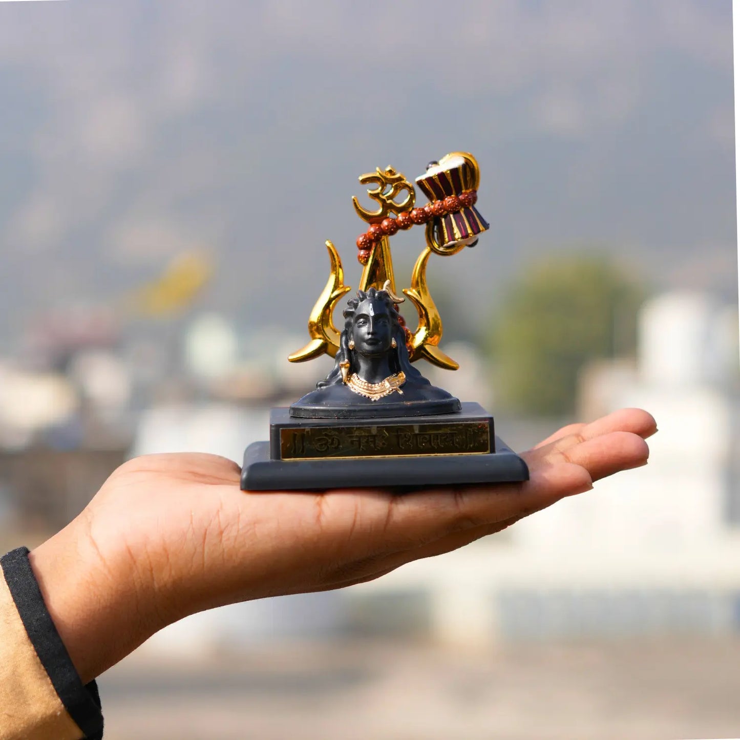 Hand holding a small statue with a blurred background