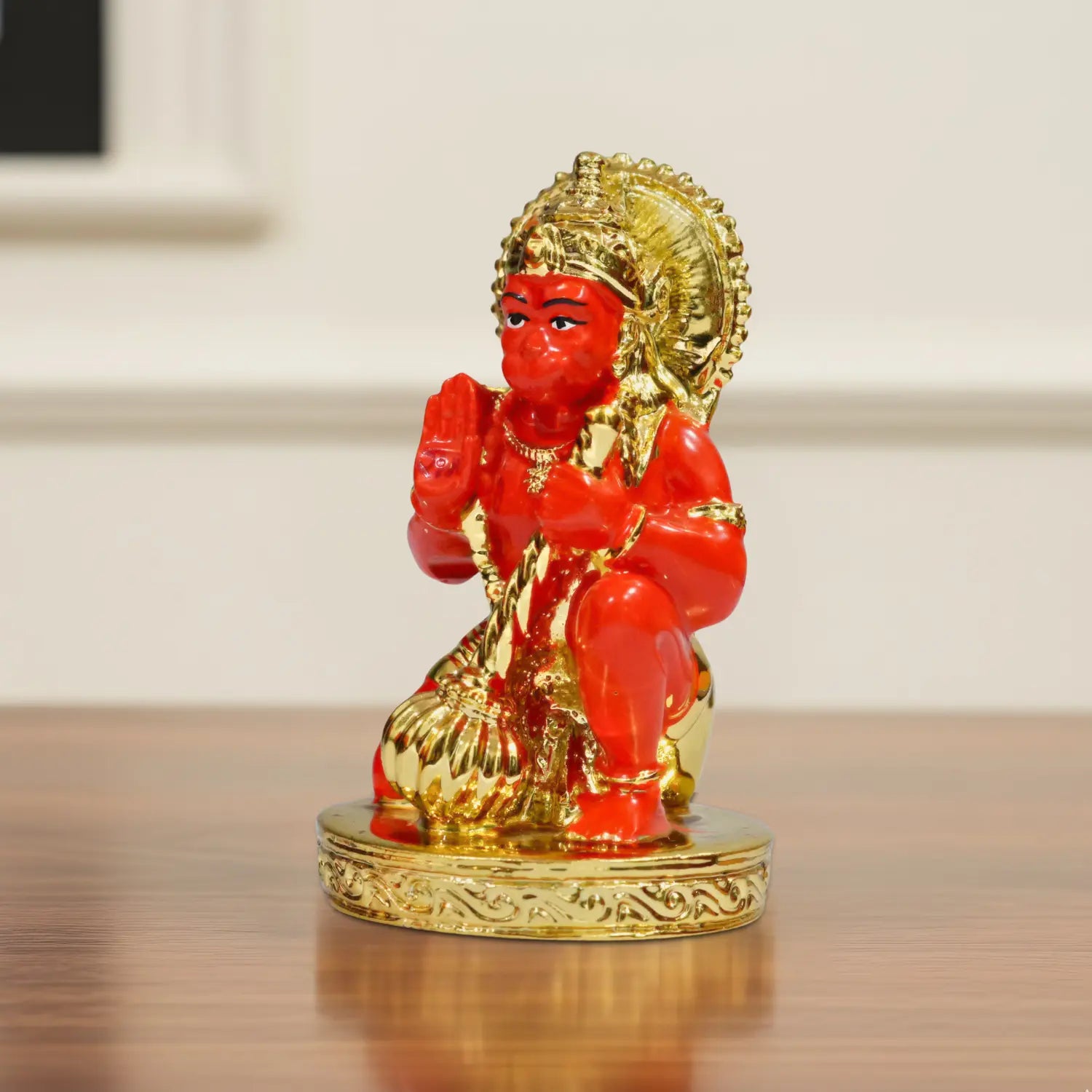 Red and gold statue on a reflective surface with a blurred background