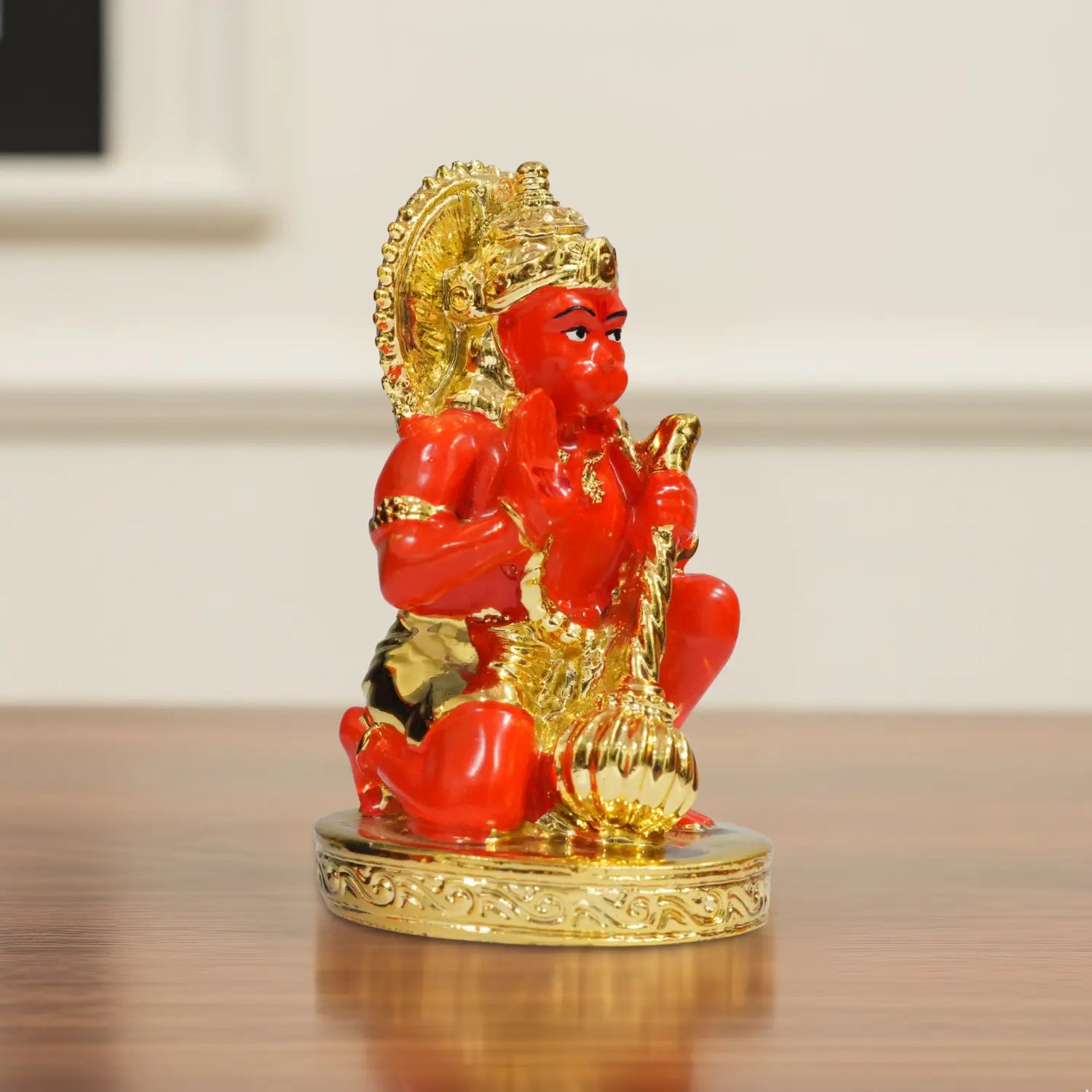 Red and gold statue on a reflective surface with a blurred background