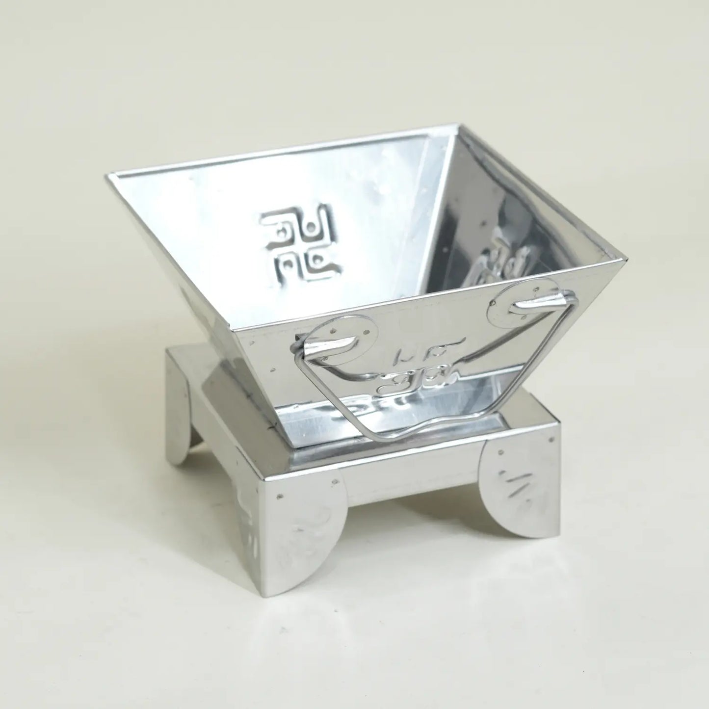 Metallic, reflective container on a light gray background