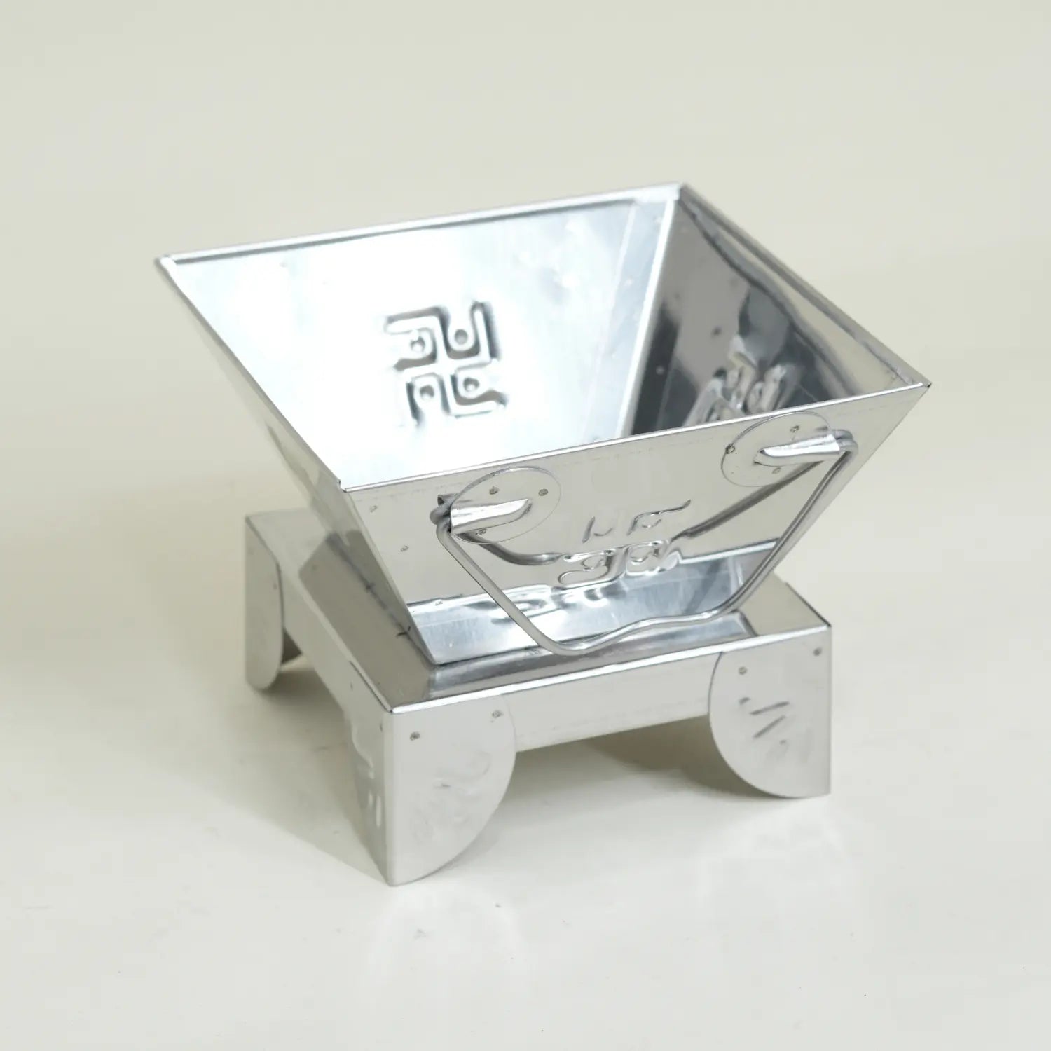 Metallic, reflective container on a light gray background