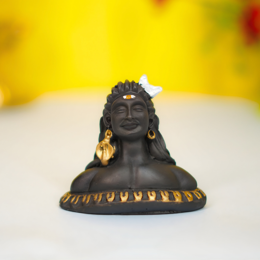 Black figurine with gold accents on a white surface with a yellow background