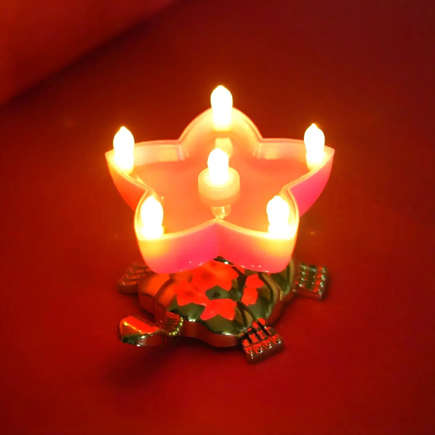 Decorative candle with a star-shaped holder on a red background