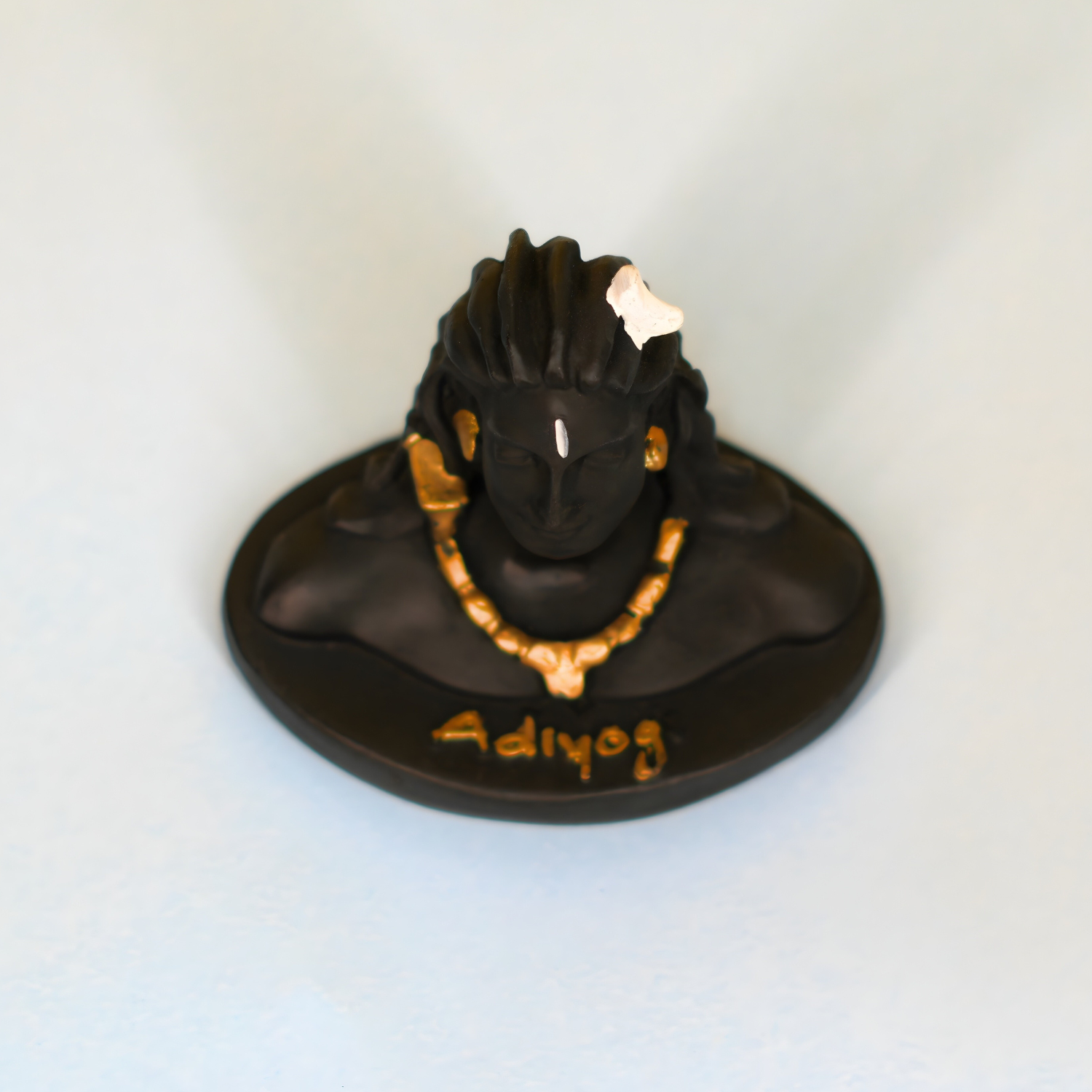 Black and gold figurine with 'Adiyog' text on a white background