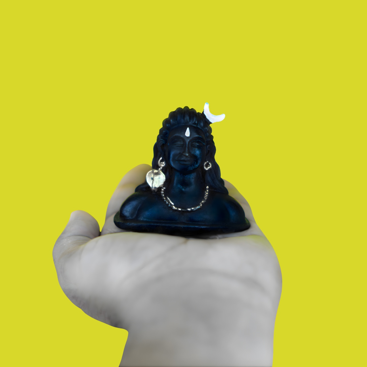 Black bust figurine held by a hand against a yellow background