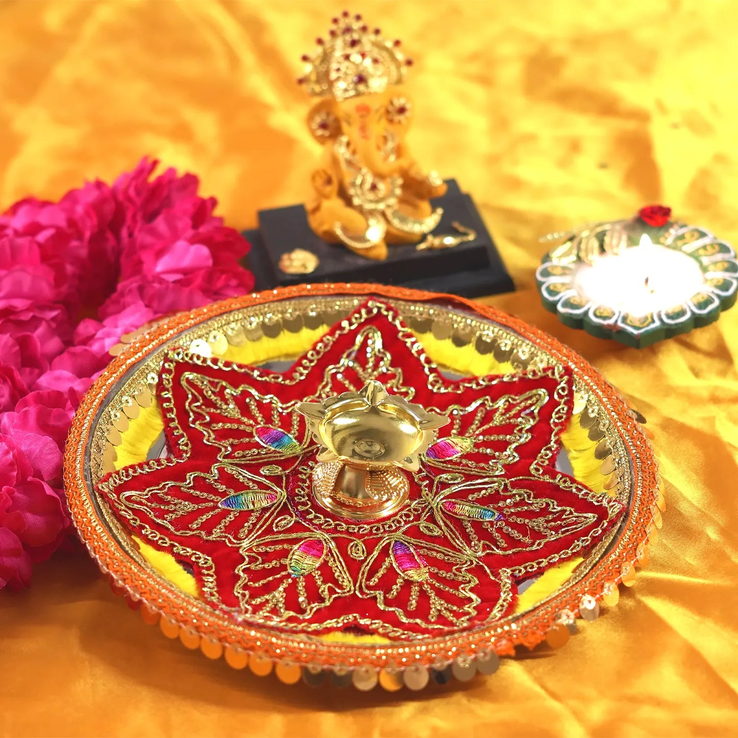 Decorative plate with red and gold design on a yellow fabric background