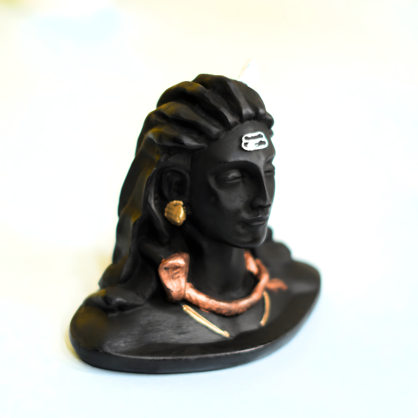 Black bust of a woman with a headdress and jewelry on a white background