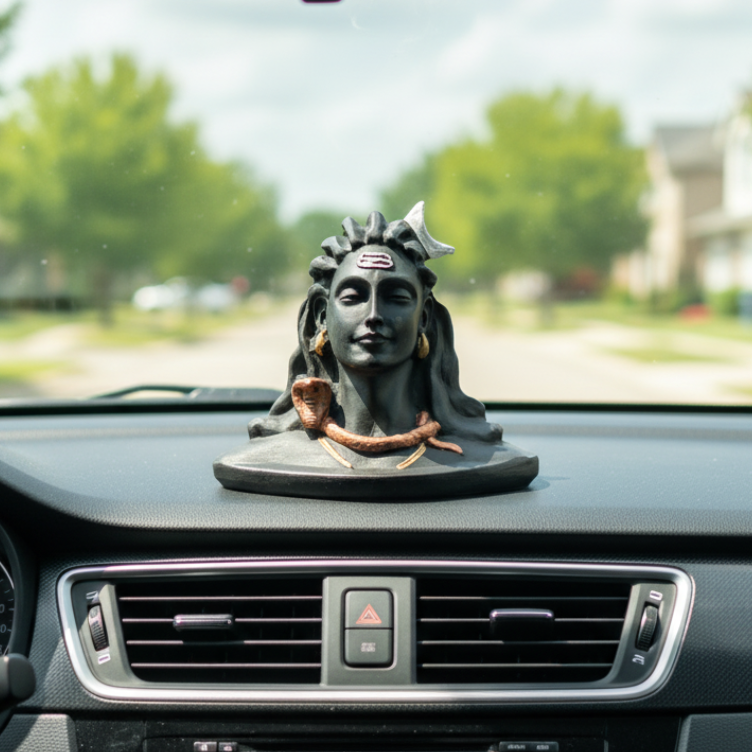 Car dashboard with a decorative statue of a woman's head.