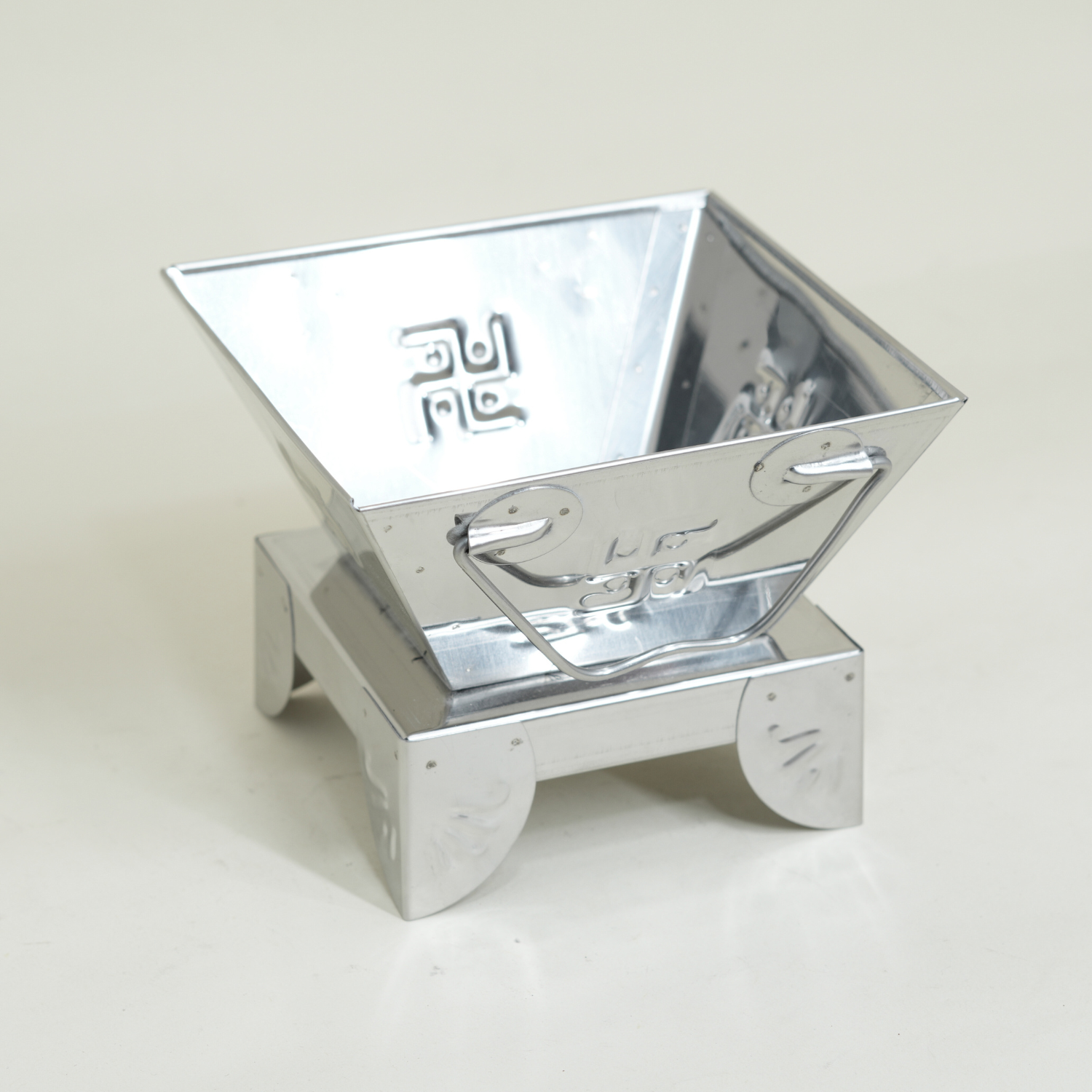 Metallic, reflective container on a light gray background