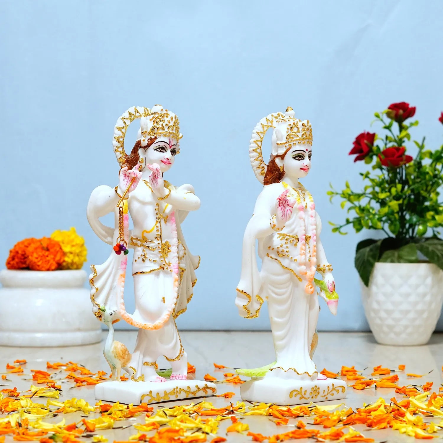 Two figurines of a couple with decorative elements on a light blue background with flowers.