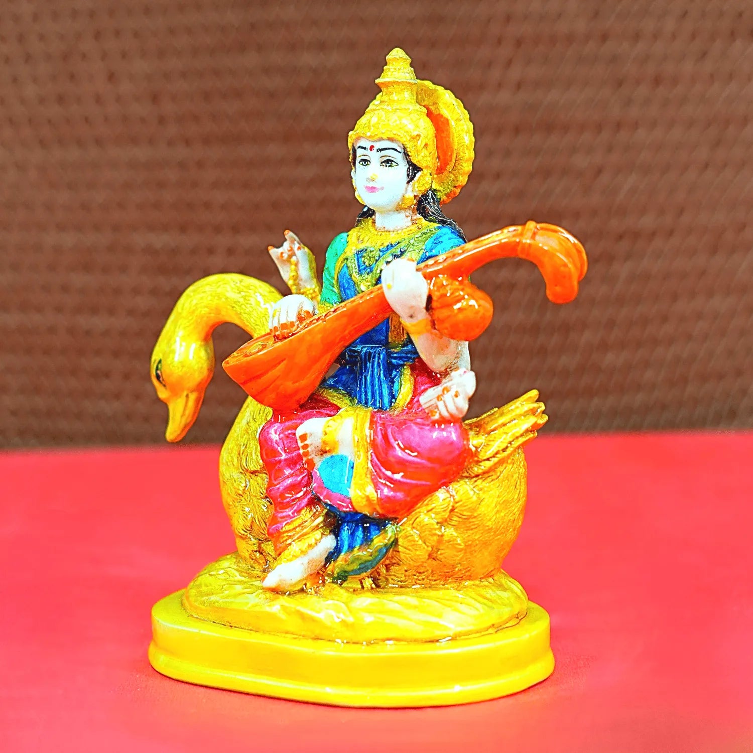 Colorful figurine of a deity on a goose with a blurred background