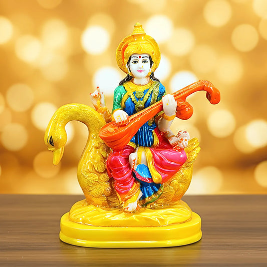 Colorful figurine of a deity on a swan with a blurred golden background
